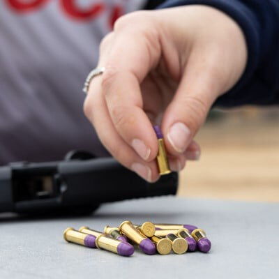 CCI ammo cartridges being picked up from a table outside