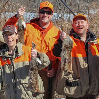 hunting party holding up their cottontails