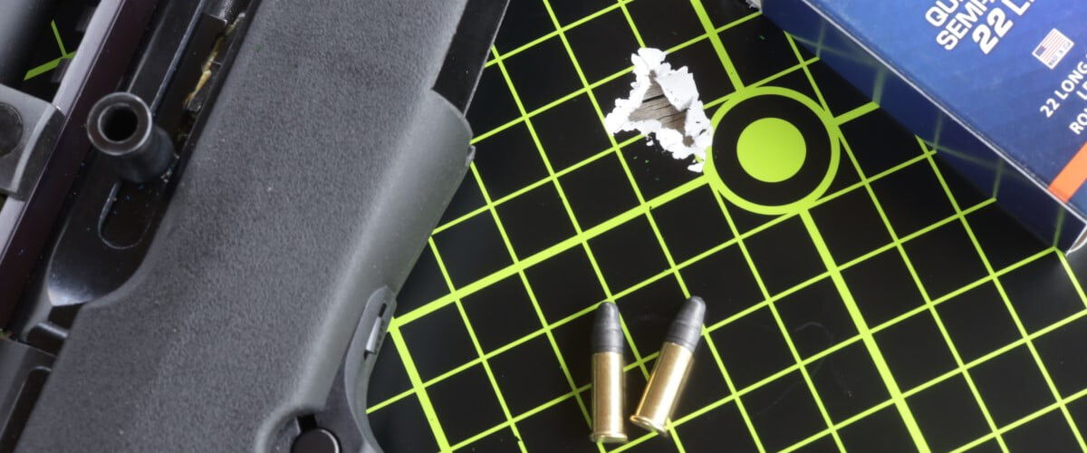 shot target with CCI packaging, cartridges and a rifle