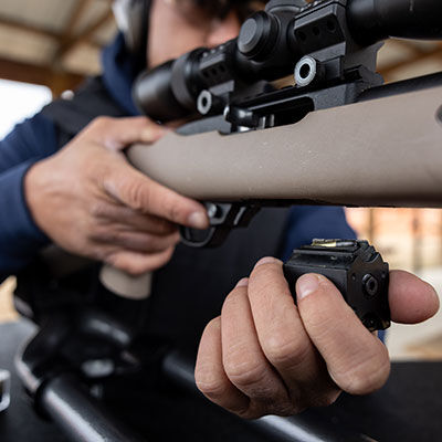 handgun with target, box of Subsonic and cartridges laying on a table