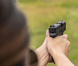 person pointing a handgun