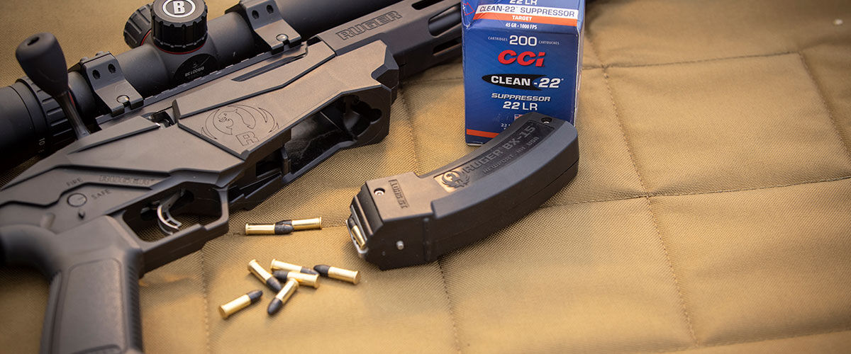 Clean-22 packaging next to a rifle with a magazine