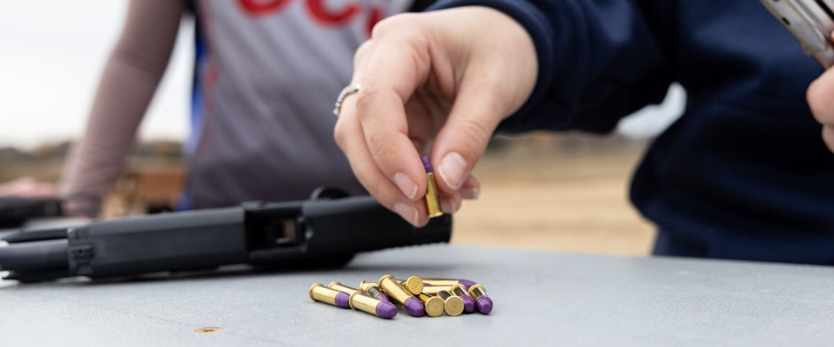 CCI ammo cartridges being picked up from a table outside