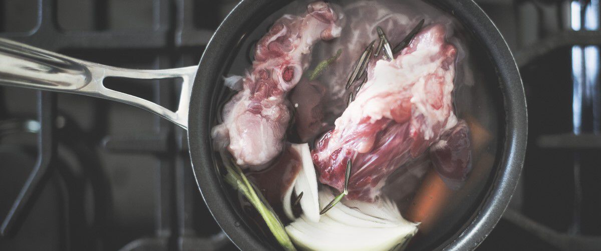 bones boiling in water in a pot on the stove