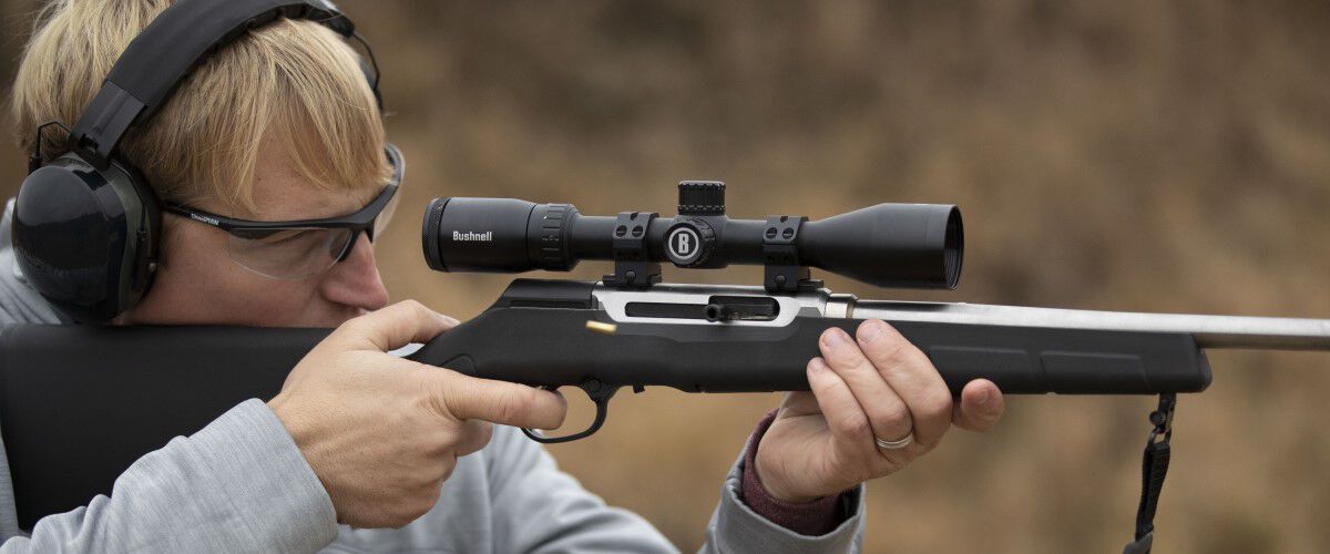 man looking down the scope of a rifle