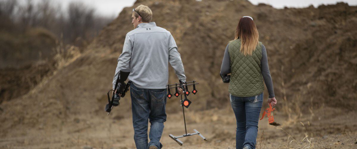 man and women walking outside carrying metal targets