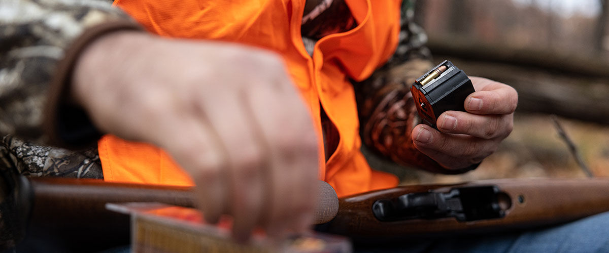 hunter loading CCI ammo into a rifle