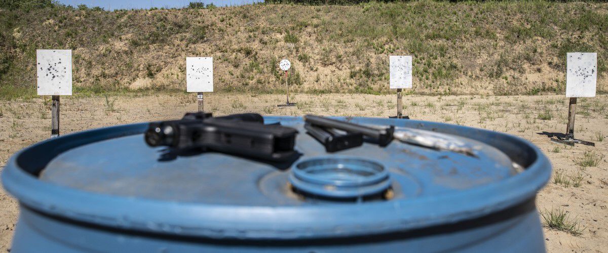 Outdoor Range with handgun resting on a blue barrel