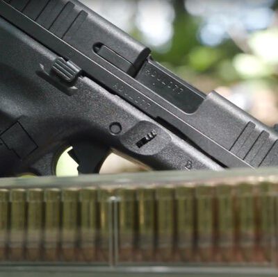 pistol and CCI ammunition sitting on a moss covered log