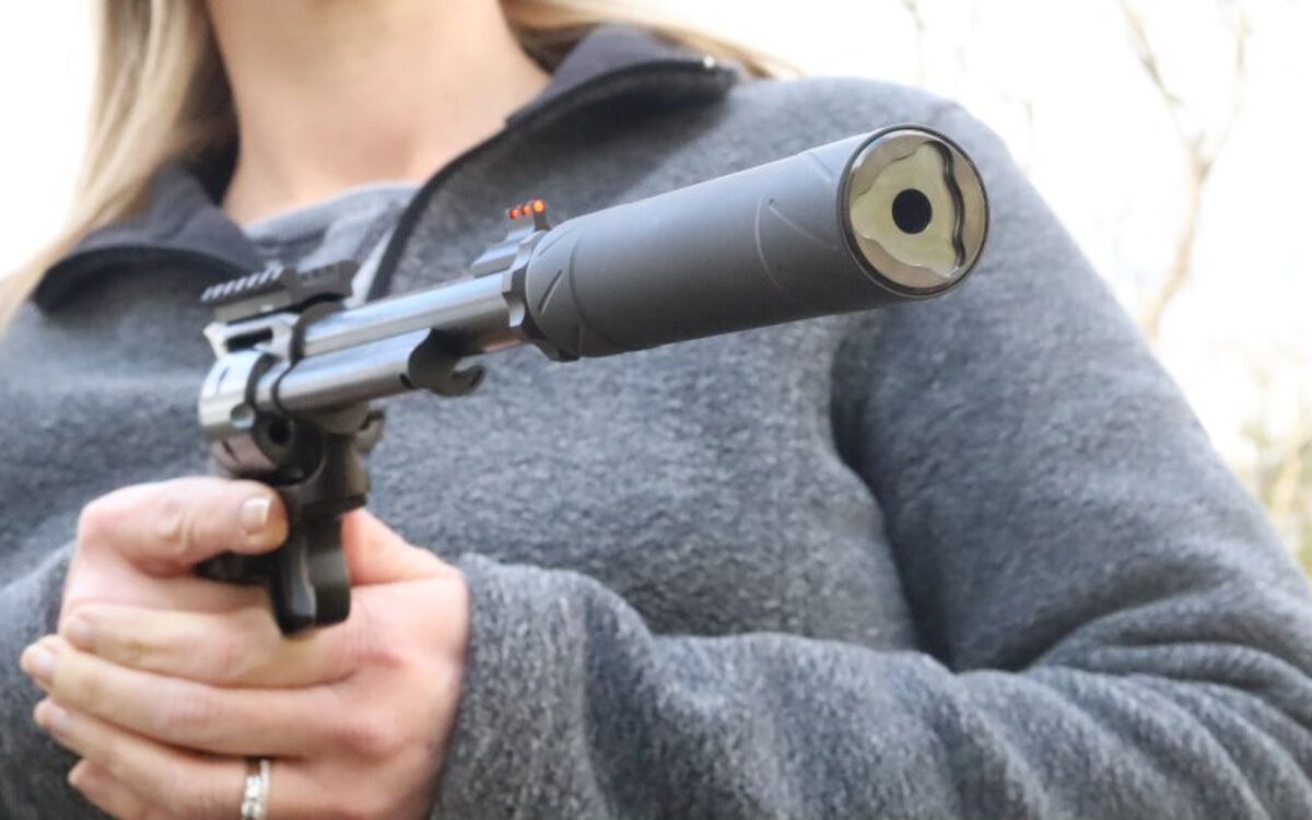 shooter holding a handgun with a silencer