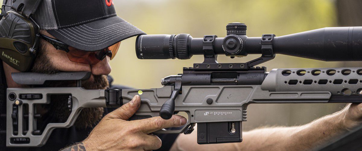 man aiming a rifle