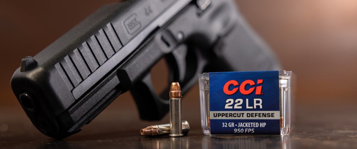 Uppercut package and cartridges on a table in front of a handgun