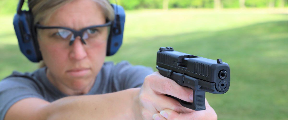 person pointing a handgun