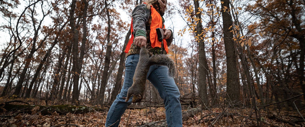 hunter carrying dead squirrel