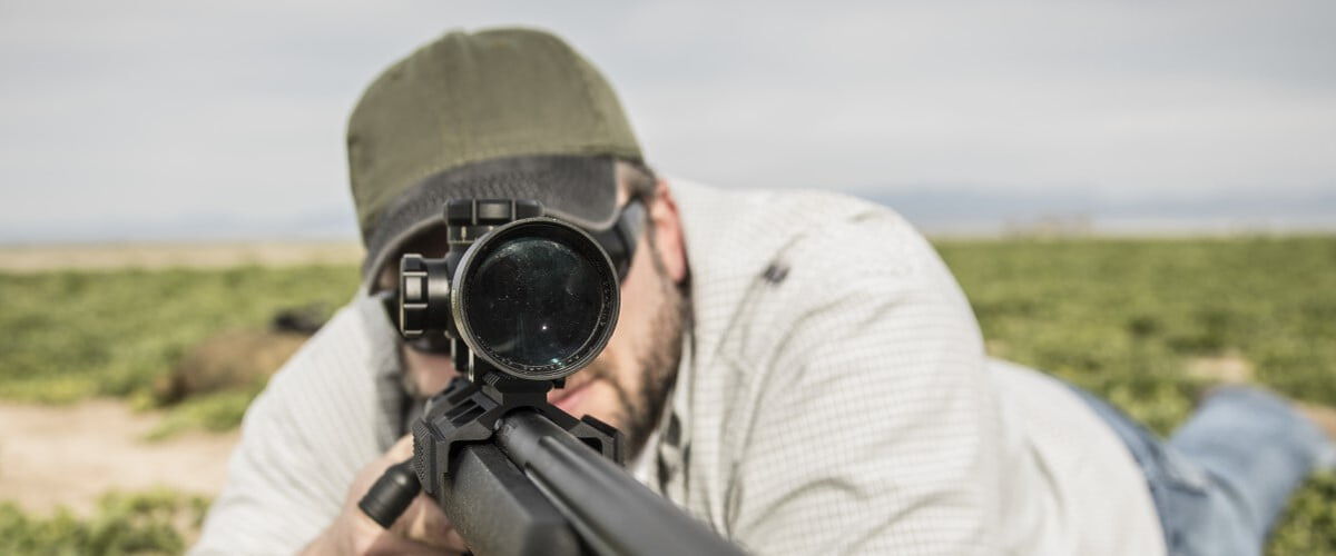 shooter looking down the scope of a rifle