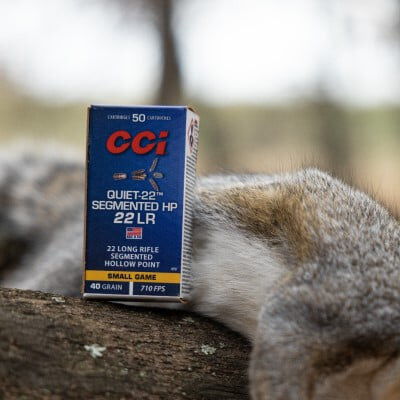 box of Quiet-22 Segmented HP 22LR on a tree branch with a dead squirrel