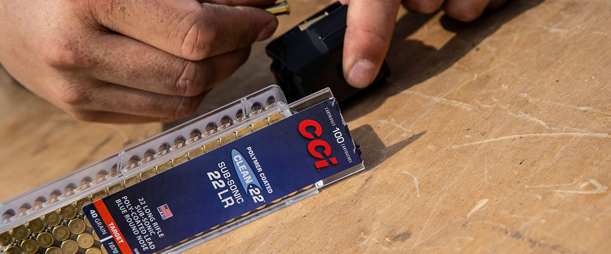 Sub-Sonic 22LR packaging next to a shooter loading a magazine