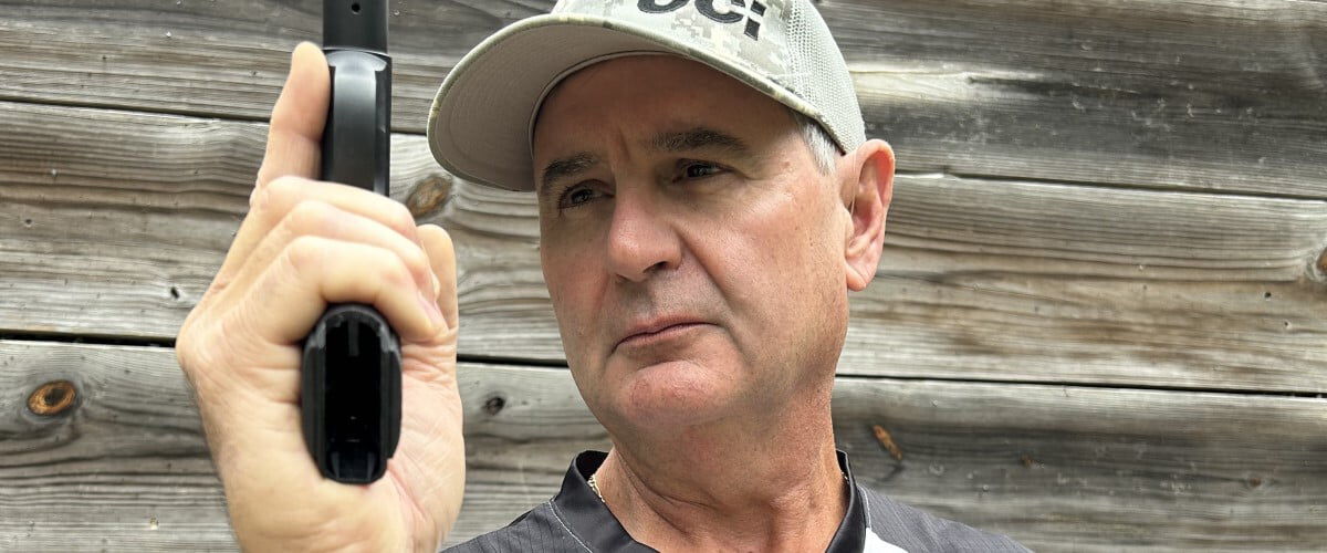 shooter aiming a handgun straight up with one hand