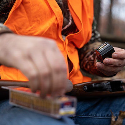 hunter loading CCI ammo into a rifle